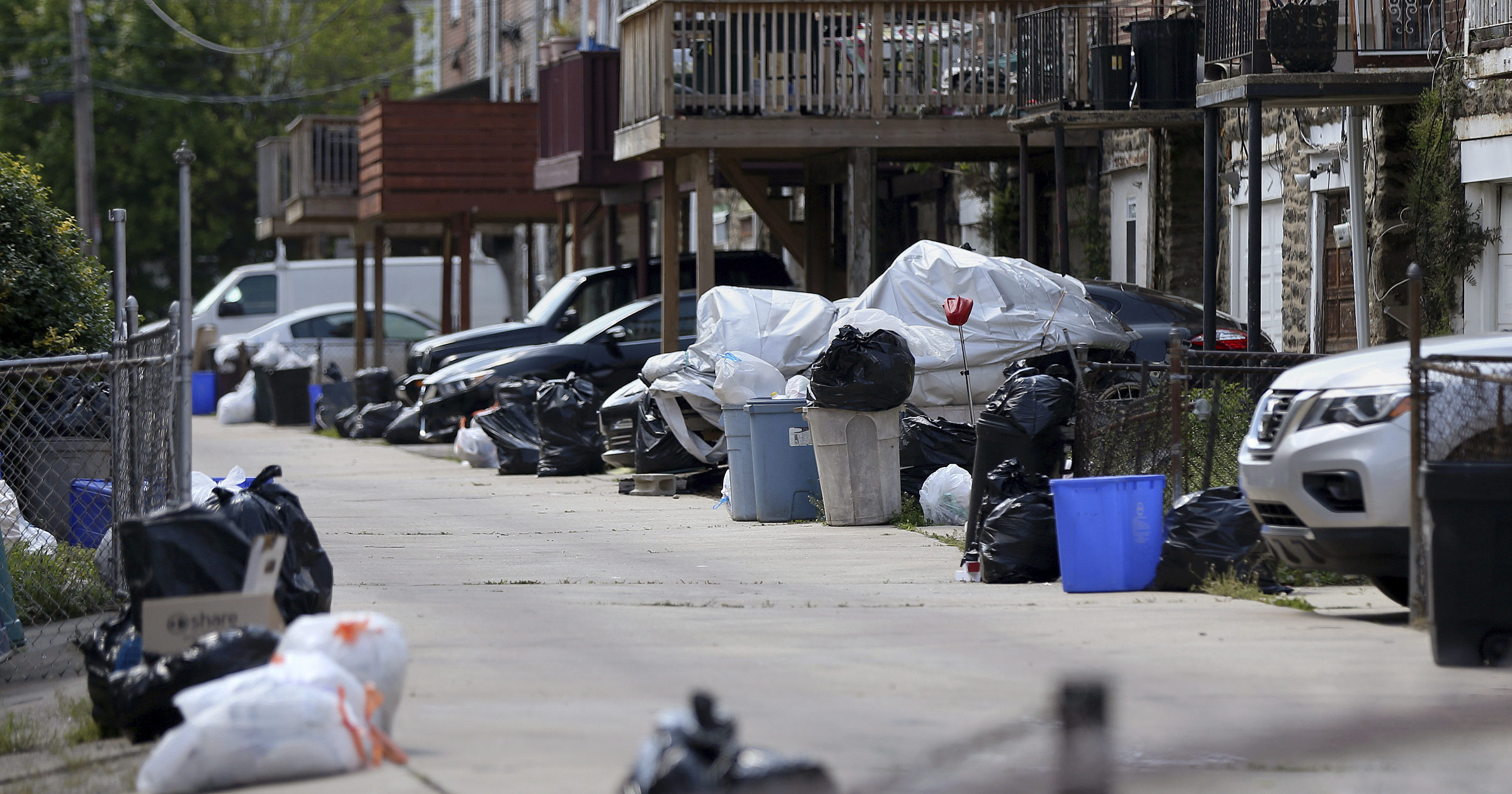In this photo from May 13, 2020, bags of garbage sit along the street in Philadelphia's Ogontz section. Households are generating more trash as people stay home due to shutdown restrictions.