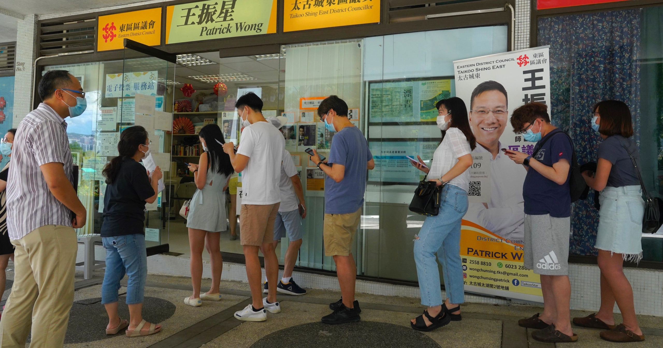 People queue up to vote in Hong Kong on July 12, 2020, in an unofficial primary for pro-democracy candidates ahead of legislative elections in September. Over 200,000 Hong Kongers voted in an unofficial Hong Kong primary that will help the pro-democracy camp decide which candidates to field in legislative elections in September. The turnout exceeded organizers' estimates that some 170,000 people would turn up to vote over the weekend.