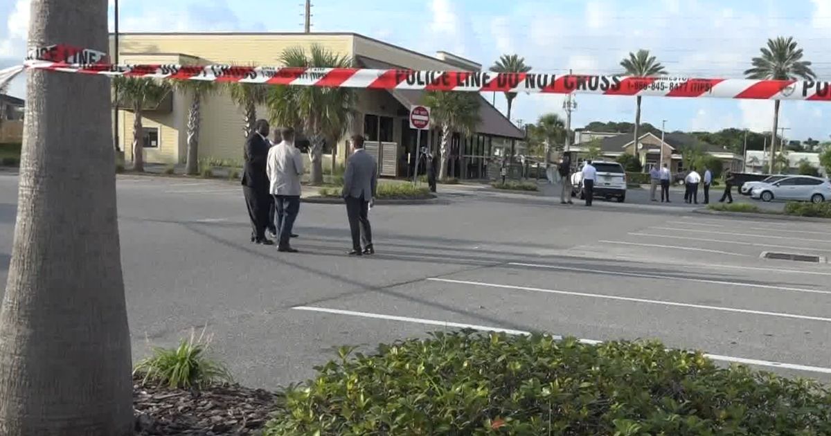 Crime scene tape blocks off a Panera Bread parking lot in Atlanta Beach, Florida, where a police officer was injured in a confrontation with a suspect.