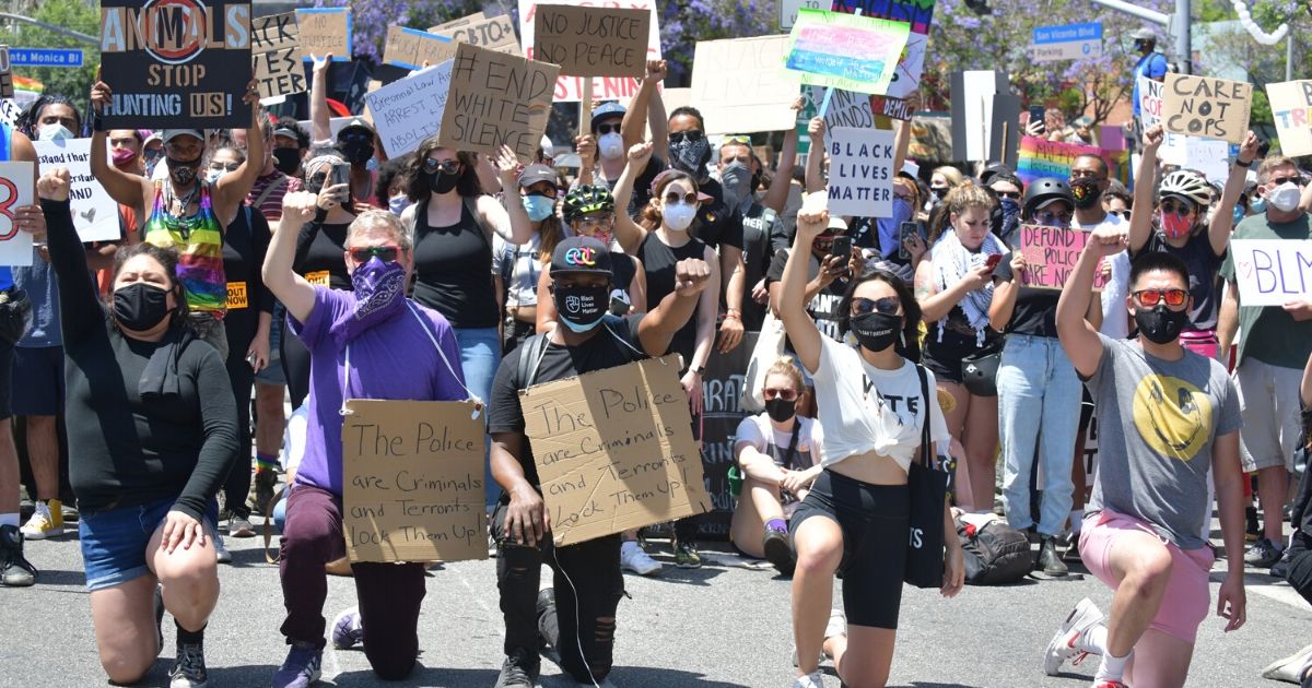 Marchers kneel in solidarity for eight minutes and 46 seconds in honor of George Floyd during the All Black Lives Matter Solidarity March on June 14, 2020, in Los Angeles, California.
