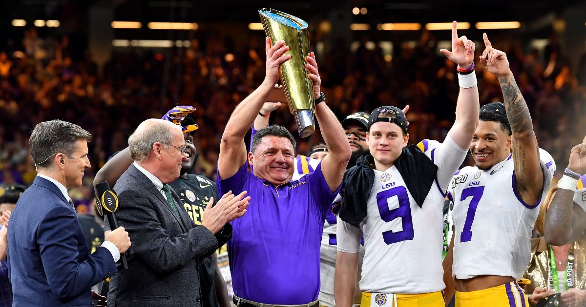 LSU head coach Ed Orgeron raises the National Championship Trophy after the Tigers beat Clemson 42-25 at the Mercedes-Benz Superdome in New Orleans on Jan. 13, 2020.