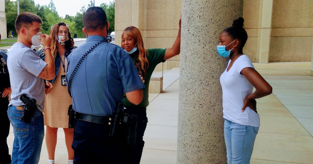 Shetara Sims and her daughter talk to officers after donating $100 won from a lottery ticket to a wounded officer.