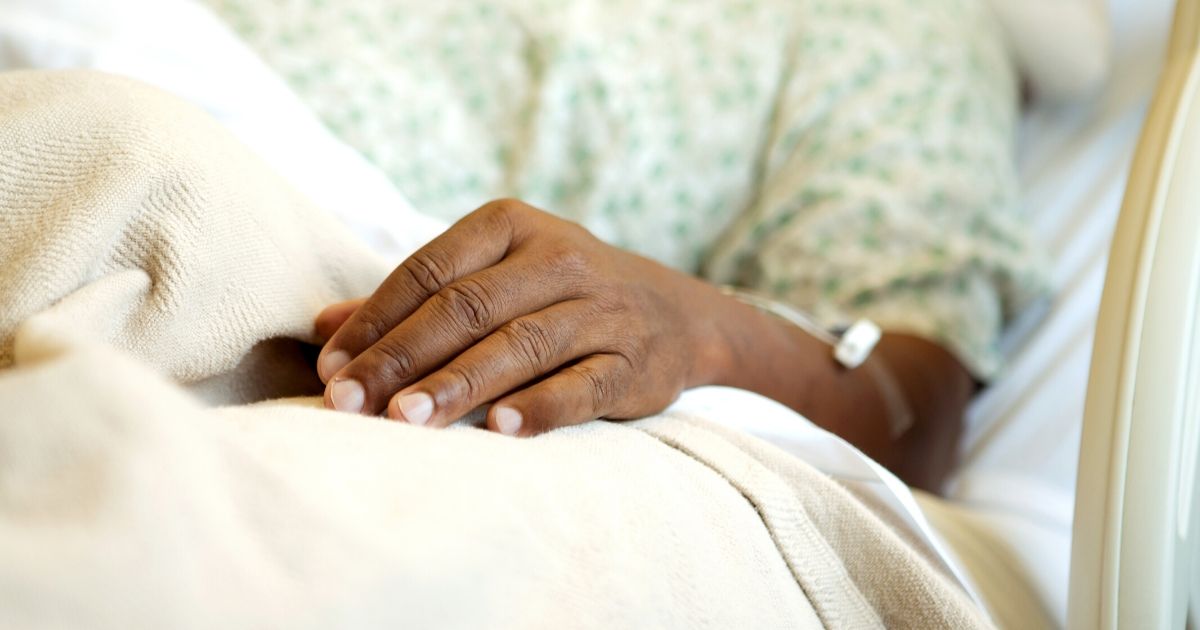 A man lying in a hospital bed.