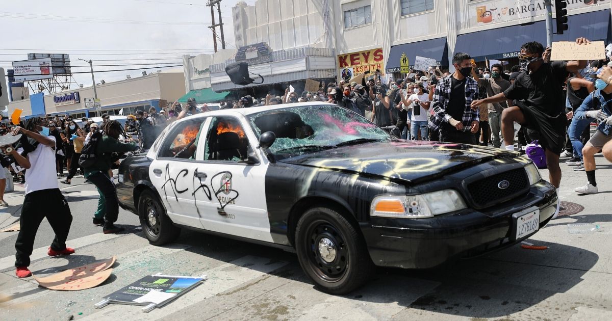 Rioters set a Los Angeles Police Department patrol car on fire May 30, 2020, during demonstrations following the death of George Floyd in Minneapolis police custody.