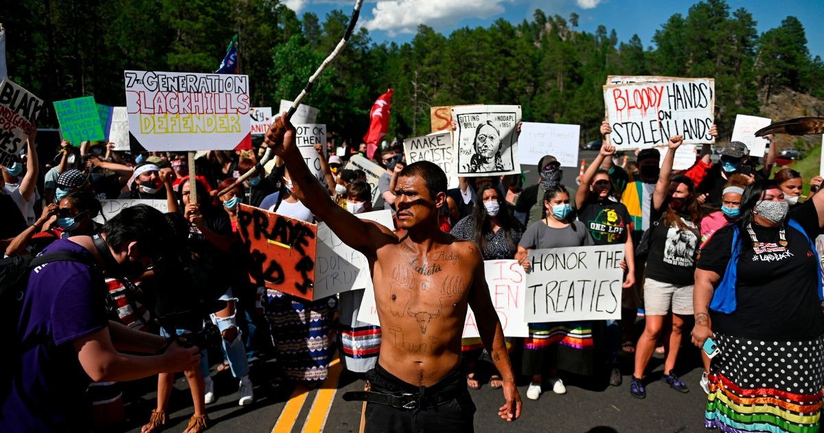 Activists and members of different tribes from the region block the road to Mount Rushmore National Monument as they protest in Keystone, South Dakota on July 3, 2020, during a demonstration around the Mount Rushmore National Monument and the visit of US President Donald Trump.