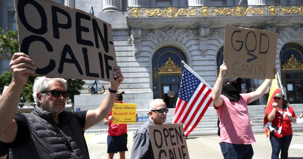 Demonstrators protest California Gov. Gavin Newsom's continued statewide shelter in place order outside of San Francisco City Hall on May 1, 2020.
