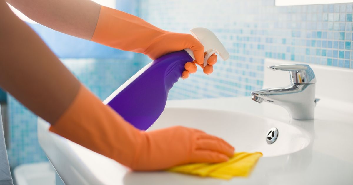 A person cleans a surface in the stock image above.