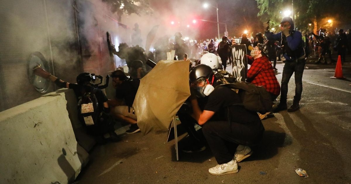 Rioters attack the Mark O. Hatfield federal courthouse in downtown Portland, Oregon, during another night of violent demonstrations in the city July 27, 2020.