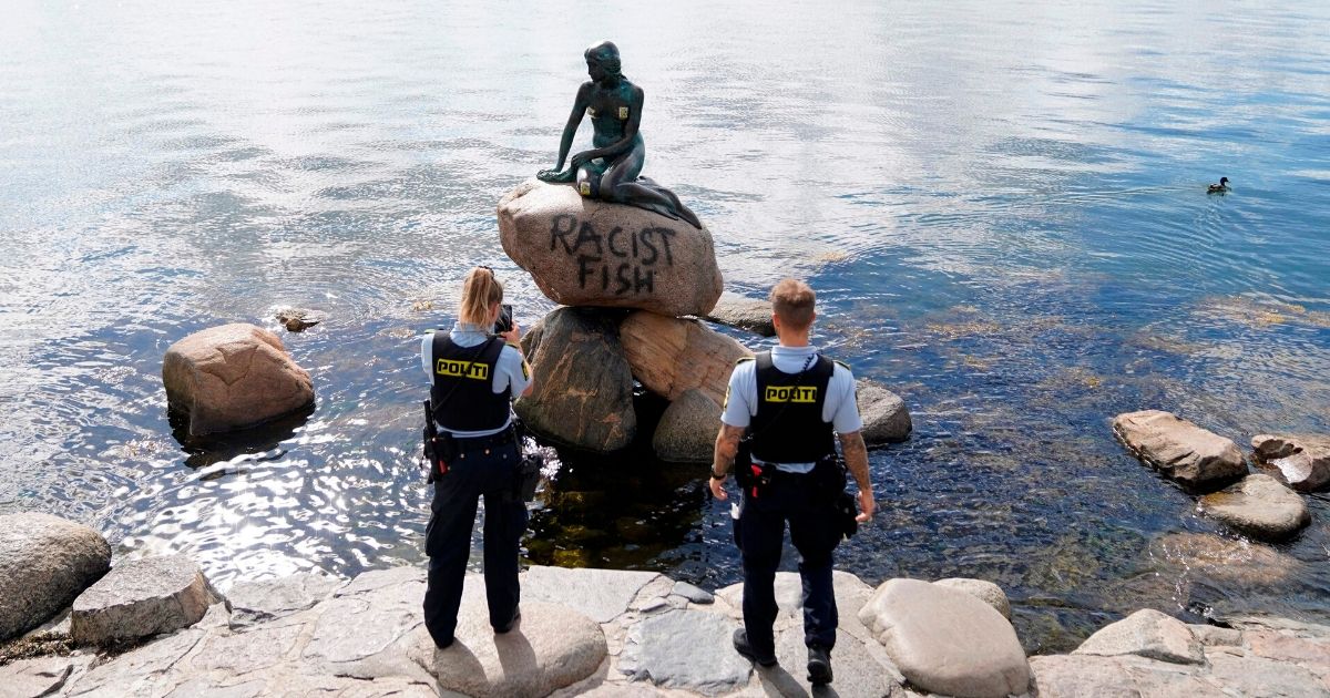 Danish police officers capture photos of the base of The Little Mermaid statue after it was vandalized on July 3, 2020.