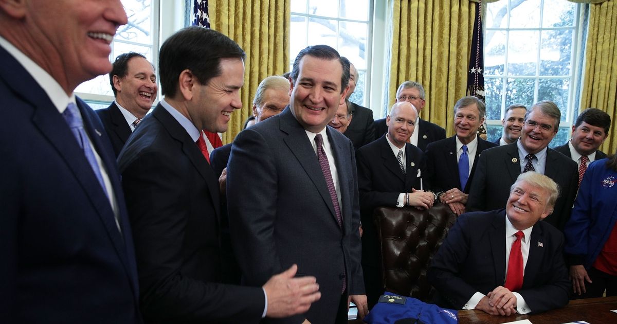 Ted Cruz and Marco Rubio share a moment as they join President Donald Trump's signing for bill to increase funding to NASA on March 21, 2017.