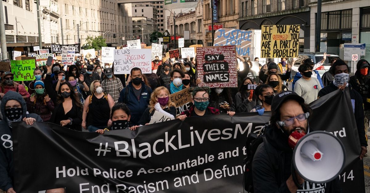 Black Lives Matter protesters march through a downtown street on June 14, 2020 in Seattle, Washington.