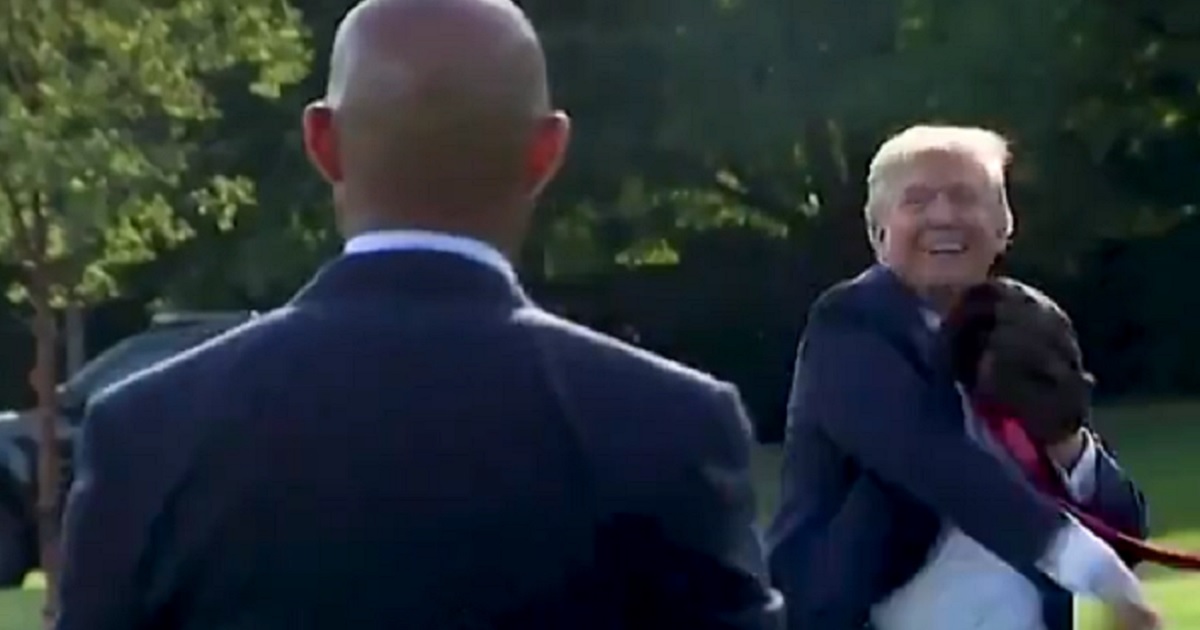 President Donald Trump grins during a game of catch on the White House lawn with former Yankees pitcher Mariano Rivera.