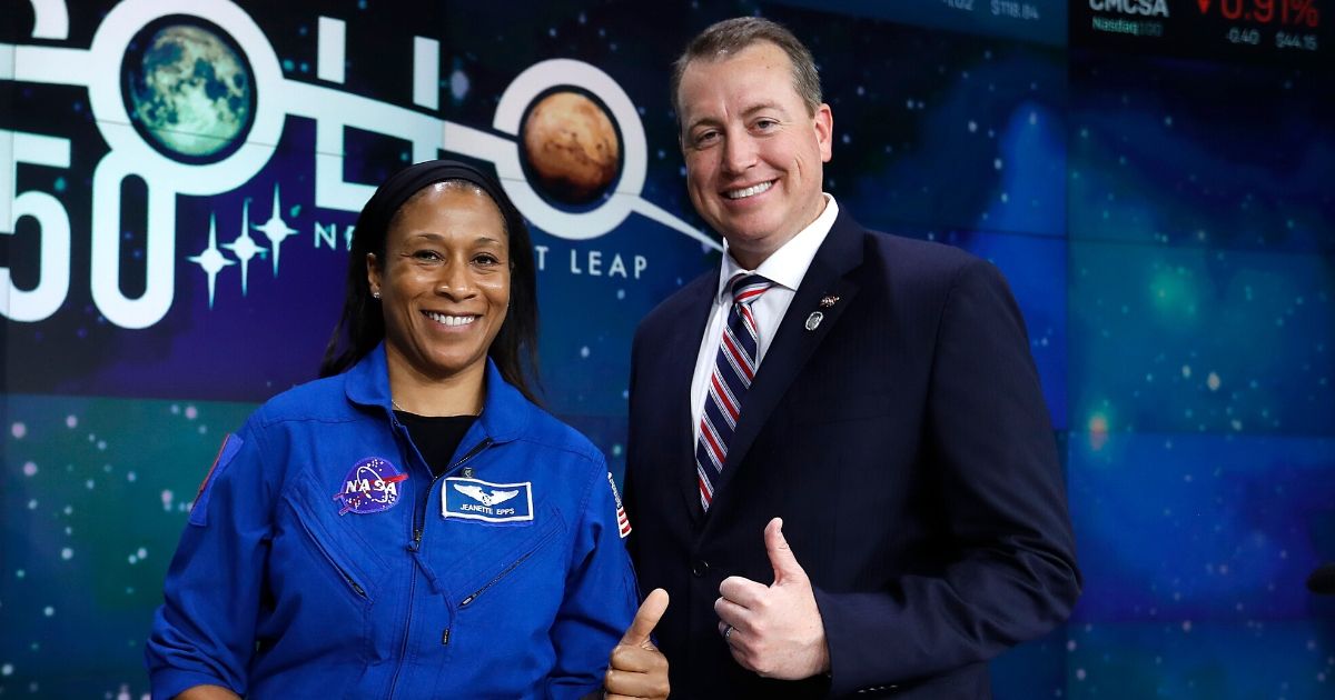 Astronaut Jeanette Epps and then-NASA CFO Jeff DeWit pose as NASA rings the closing bell at the NASDAQ on July 19, 2019, in New York City.