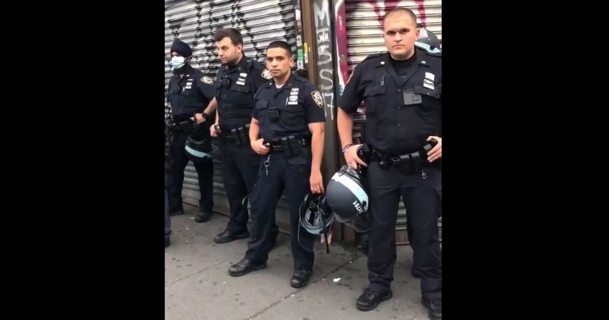Police officers in New York City listen to a man verbally abuse them.