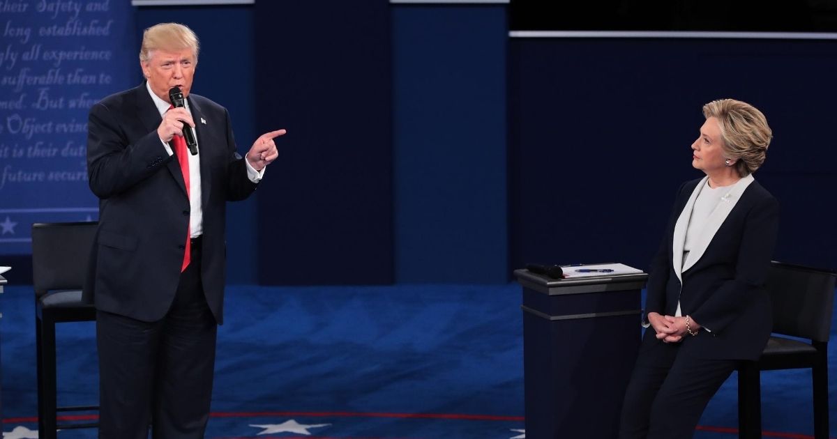 Republican presidential nominee Donald Trump speaks as Democratic presidential nominee former Secretary of State Hillary Clinton listens during the town hall debate at Washington University on Oct. 9, 2016, in St Louis.