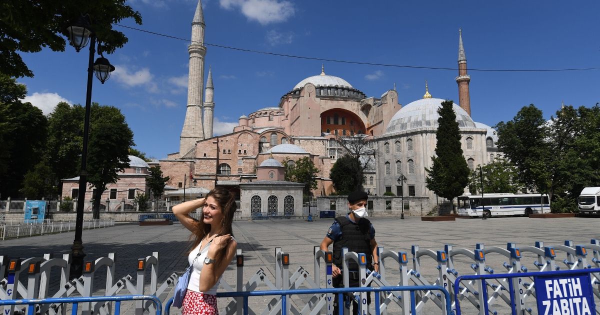 A woman poses for a picture in front of Hagia Sophia on July 11, 2020, in Istanbul, a day after a top Turkish court revoked the Hagia Sophia's status as a museum, clearing the way for it to be turned back into a mosque.