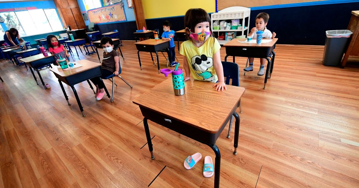 Children in pre-school wear masks at desks spaced apart per coronavirus guidelines in Monterey Park, California, on July 9, 2020. North Carolina Gov. Roy Cooper has ordered schools to open for fall instruction -- as long as they meet safety precautions.