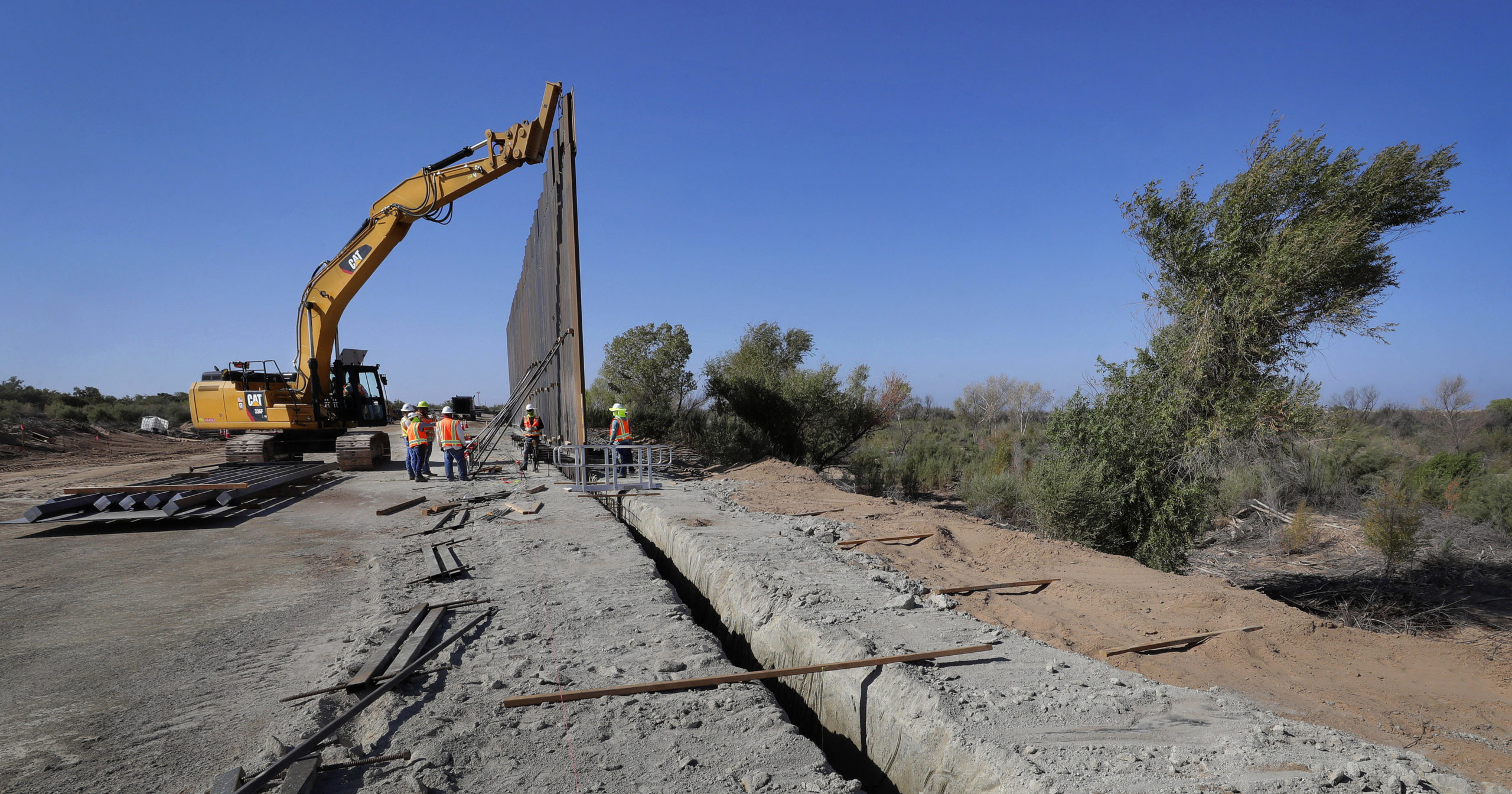 In this Sept. 10, 2019, file photo, government contractors erect a section of the border wall along the Colorado River in Yuma, Arizona. The federal Bureau of Land Management said on July 21, 2020, that it's transferred over 65 acres of public land in Arizona and New Mexico to the Army for construction of border wall infrastructure.