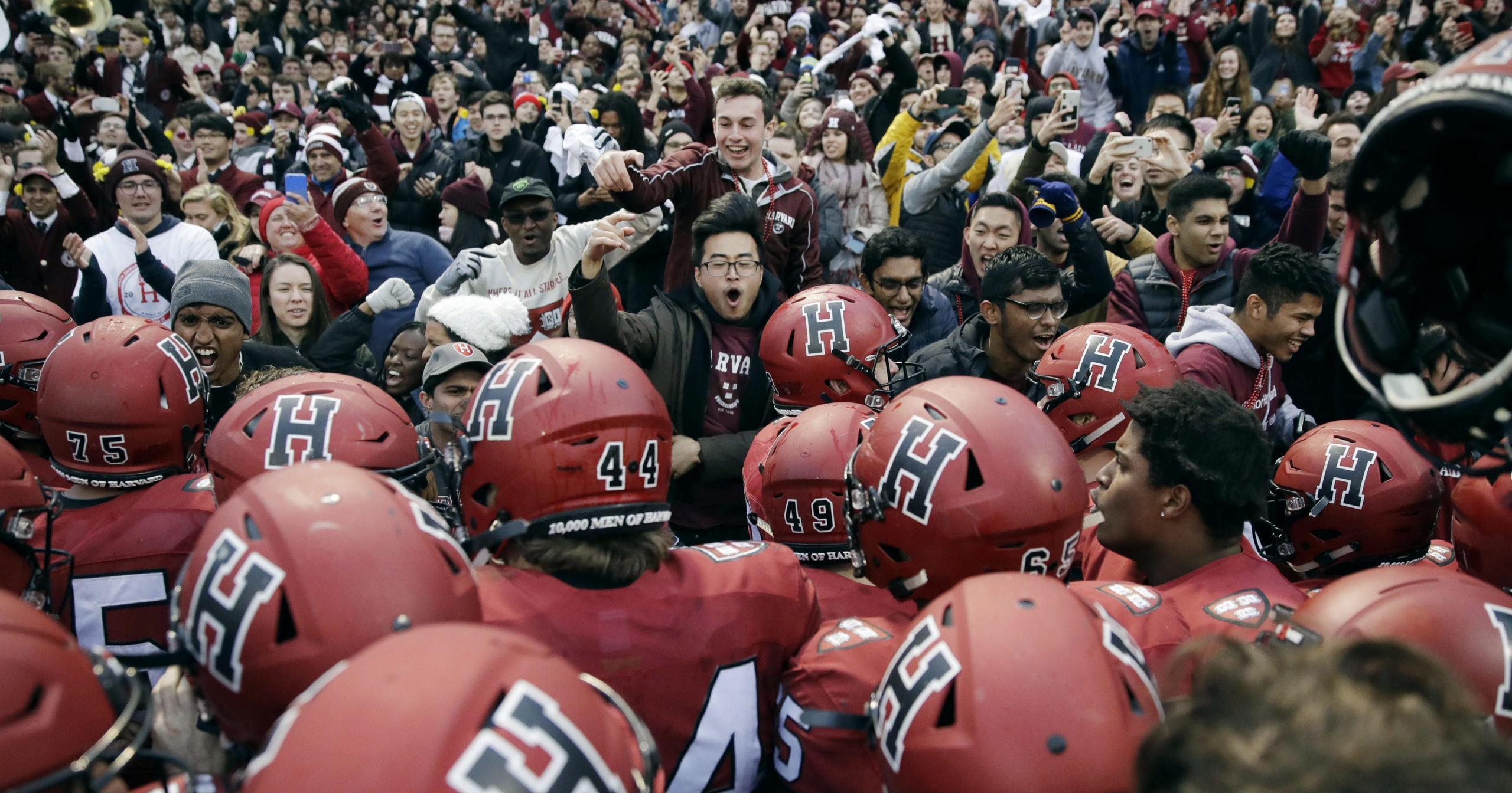 In this Nov. 17, 2018, file photo, Harvard players, students and fans celebrate their 45-27 win over Yale after an NCAA college football game at Fenway Park in Boston. The Ivy League has canceled all fall sports because of the coronavirus pandemic.