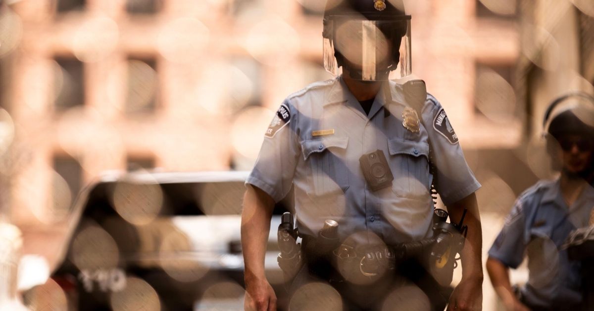 Members of the Minneapolis Police Department are seen through a chain link gate on June 13, 2020, in Minneapolis, Minnesota.