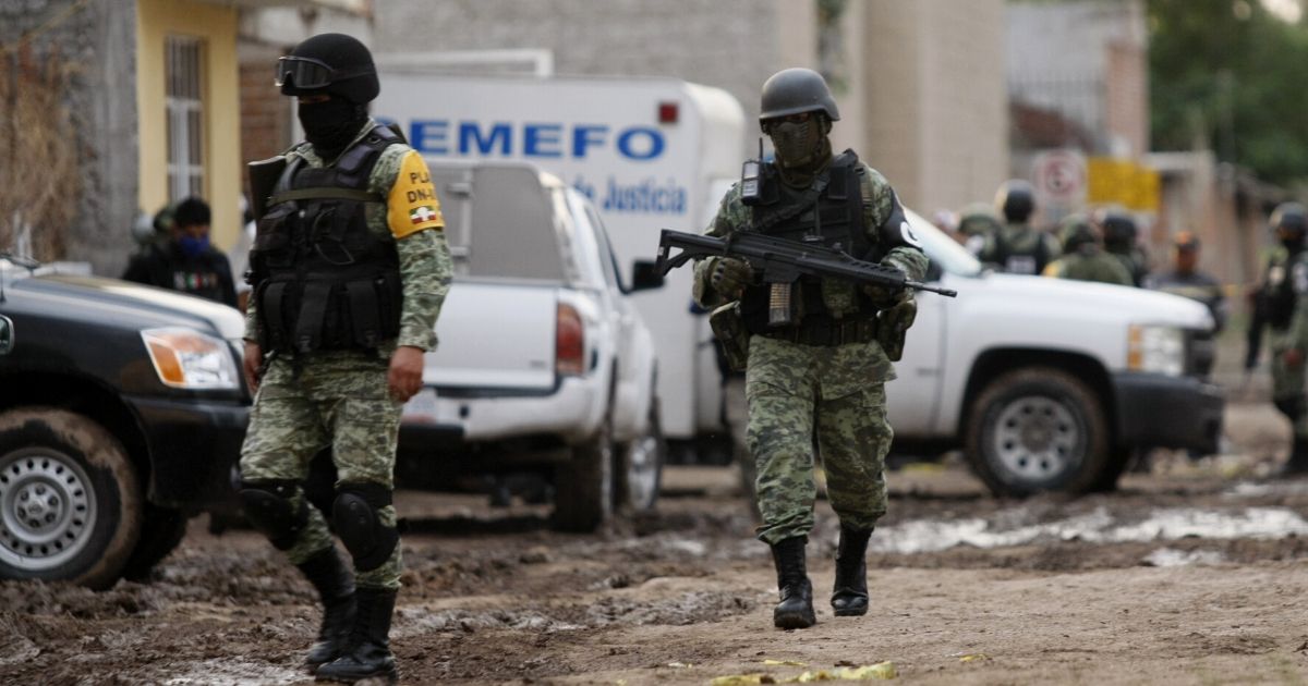 Members of the National Guard walk near the crime scene where 26 people were killed in Irapuato, Mexico, on July 1, 2020.