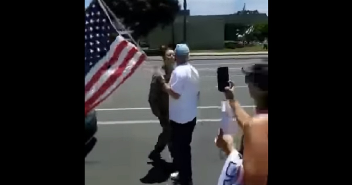 A sailor identified by the Navy as Aviation Boatswain’s Mate 2nd Class Sarah J. Dudrey berates a Trump supporters holding an American flag during a confrontation July 19 in Ventura, California.