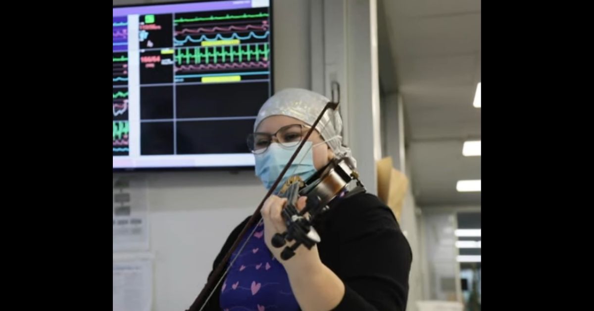 Dámaris Silva playing her violin in the halls of the COVID ward to bring some hope to the patients.