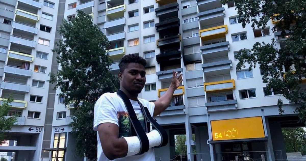 Athoumani Walid stands where he helped catch children falling from the window of a burning apartment in Grenoble, France.