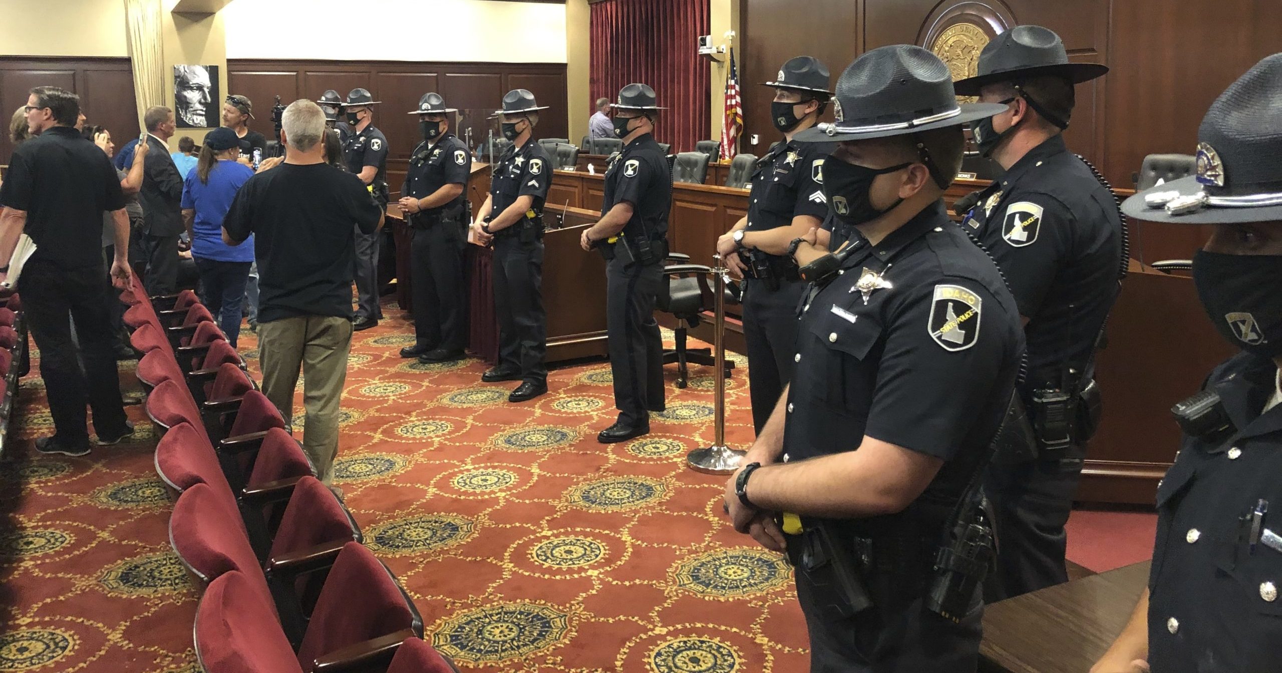 Idaho State Police stand guard in a committee meeting room in the Idaho Statehouse in Boise, Idaho, on Aug. 25, 2020. The committee left the room as a crowd of more than 100 became disruptive.