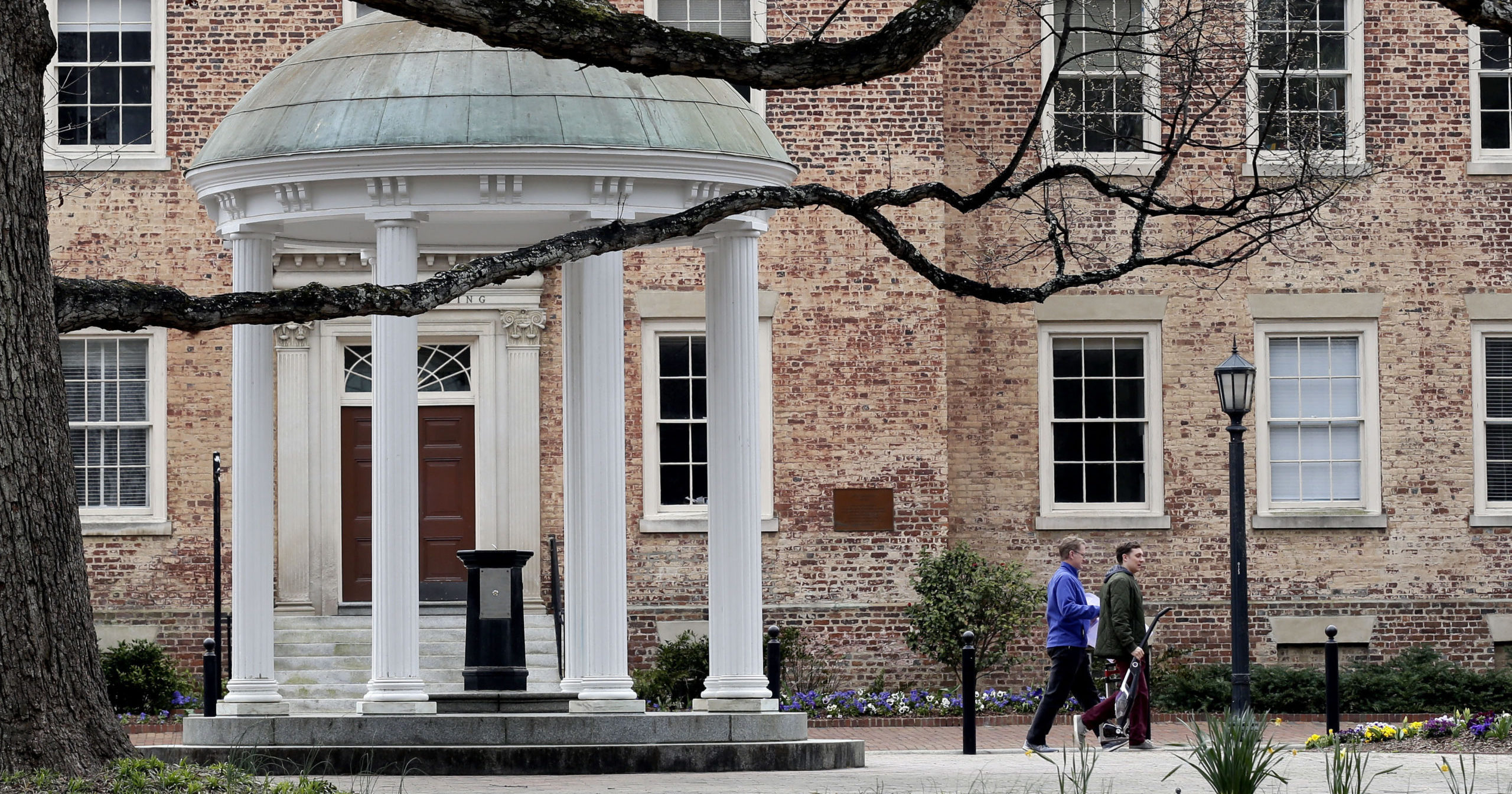 In this March 18, 2020, file photo, people remove belongings on campus at the University of North Carolina in Chapel Hill, North Carolina.