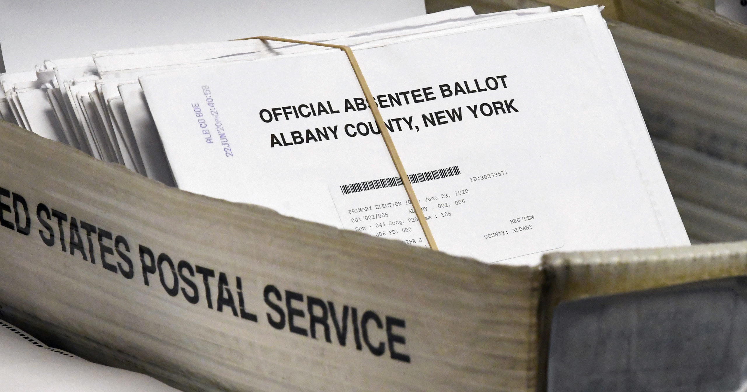 In this June 30, 2020, file photo, absentee ballots wait to be counted at the Albany County Board of Elections in Albany, New York. New York will allow voters to request absentee ballots for the general election because of the coronavirus under a new state law signed by Gov. Andrew Cuomo on Aug. 20.