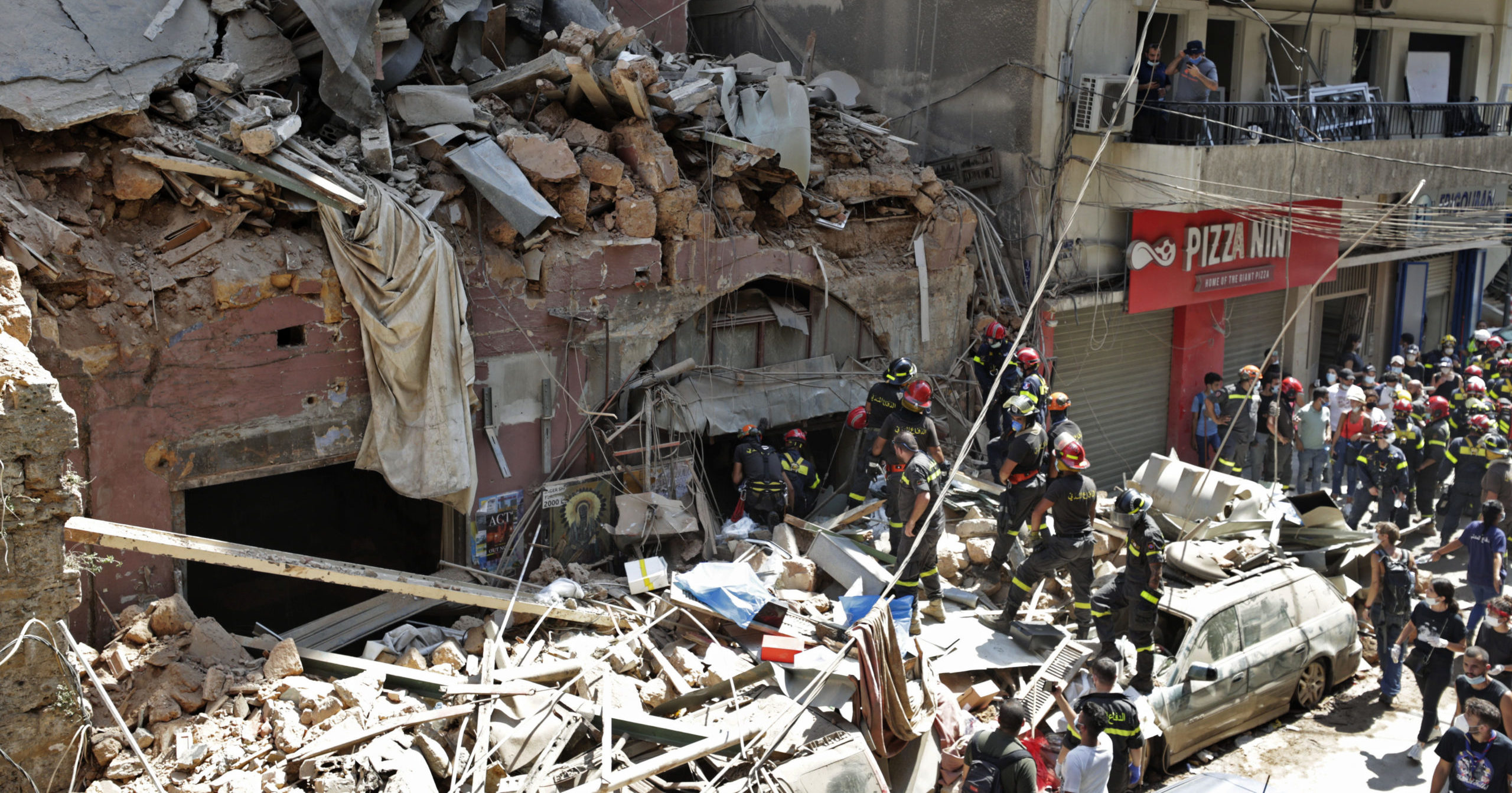French and Lebanese firemen search in the rubble of a destroyed building after an explosion at the seaport in Beirut, Lebanon, on Aug. 6, 2020.