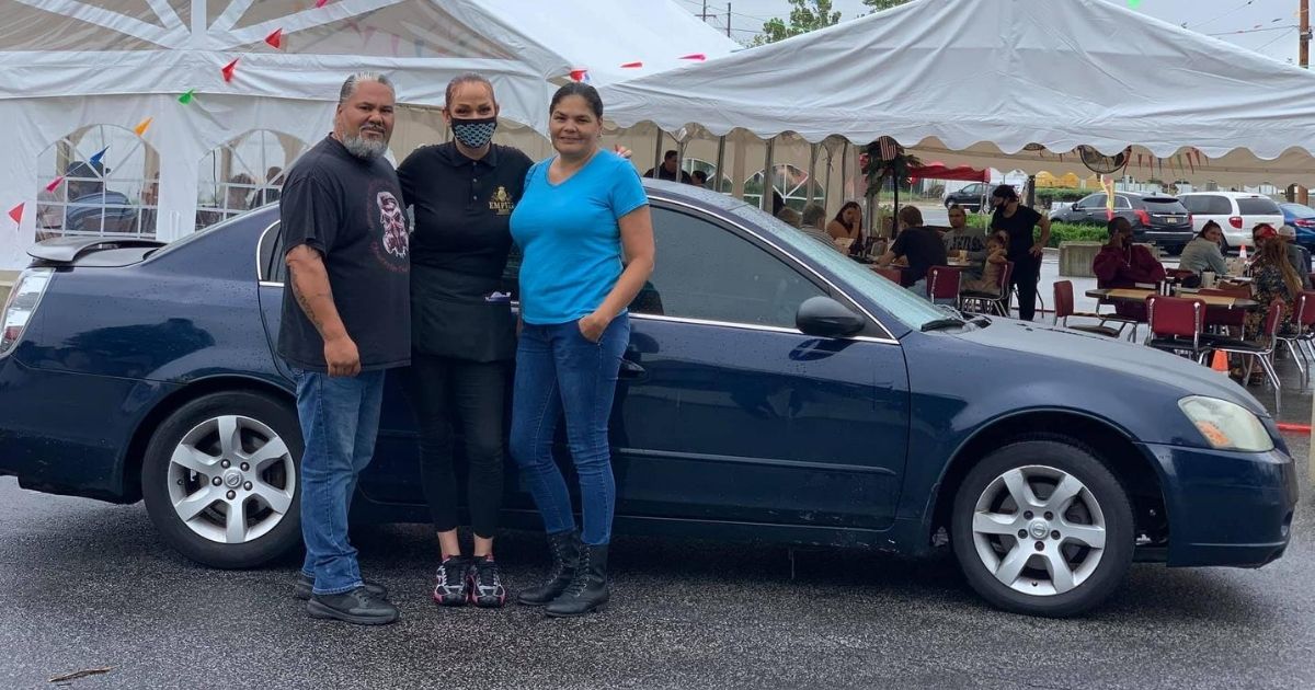 Waitress Lisa Mollet stands in front of the car she was given by a generous local couple.