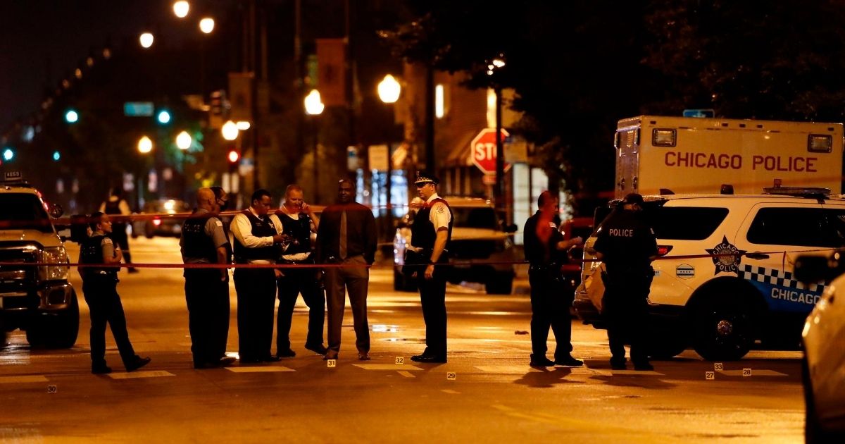 Chicago police officers investigate the scene of a shooting outside a funeral that left 14 people wounded July 21, 2020.