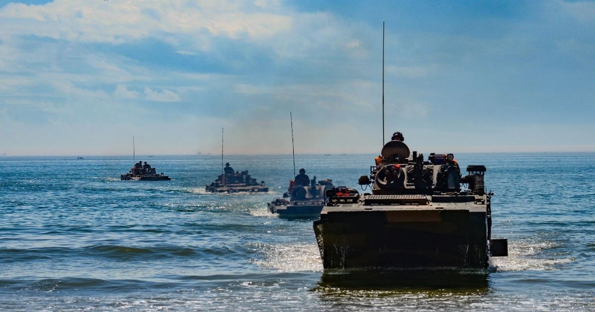 Chinese ZBD-05 amphibious infantry fighting vehicles head to shore in formation during beach raid training in south Fujian Province on July 12, 2017.
