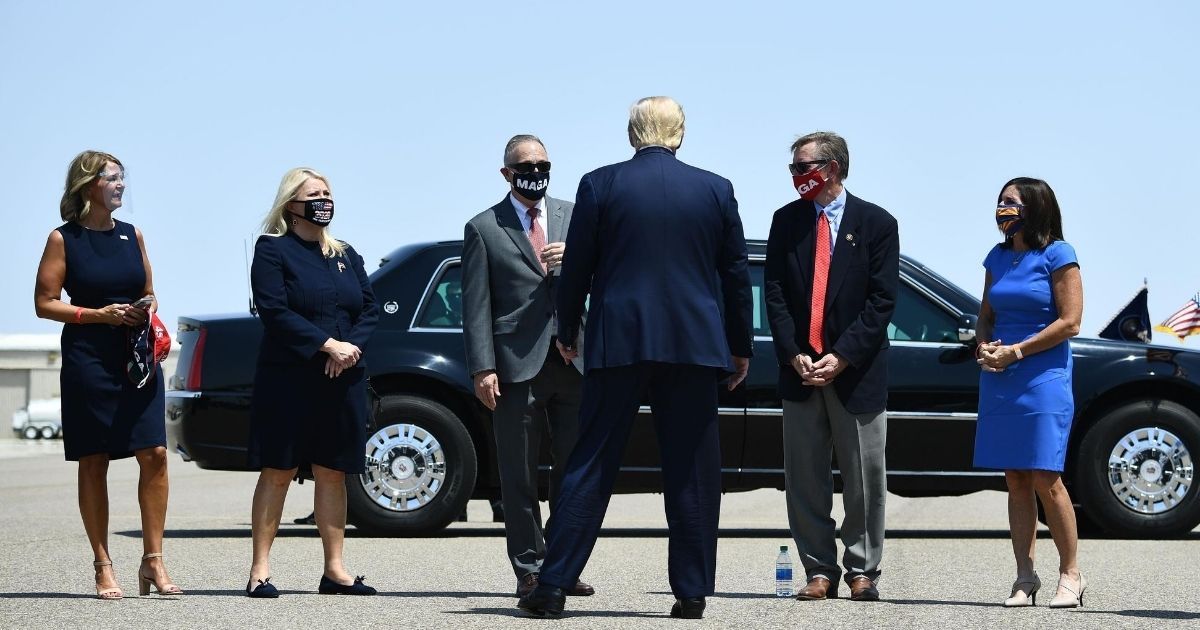From left to right, Arizona Republican Party Chairwoman Kelli Ward, Republican Reps. Debbie Lesko, Andy Biggs and Paul Gosar of Arizona, and Sen.Martha McSally of Arizona greet President Donald Trump on the tarmac after he arrived at the international airport in Yuma, Arizona, on Aug. 18, 2020.