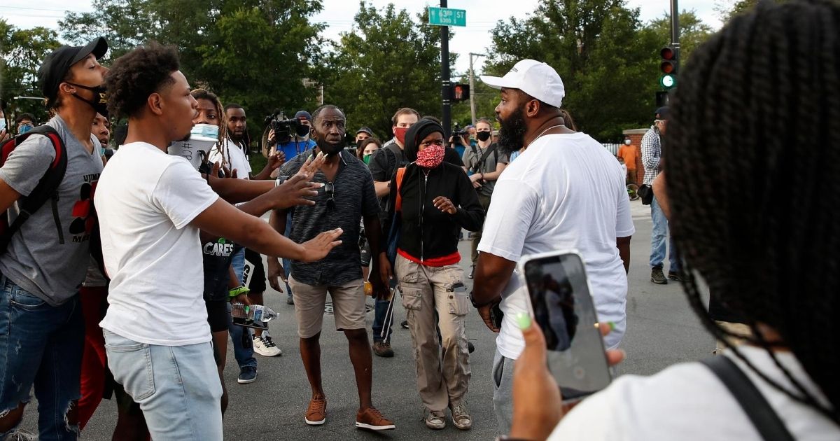 Residents, right, exchange words with demonstrators, left, during an anti-police rally in the Englewood neighborhood of Chicago on Aug. 11, 2020.