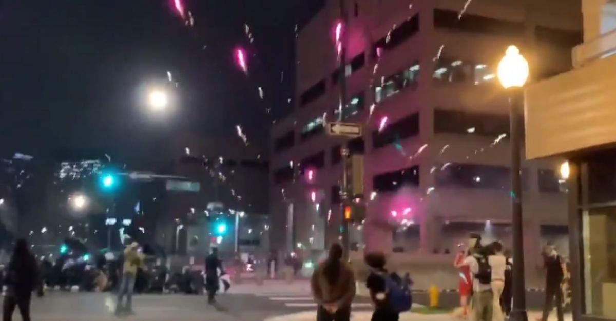 Protestors set off fireworks at police officers at a riot in Denver on Saturday.