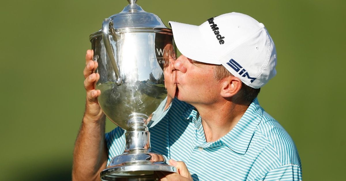Jim Herman celebrates with the trophy on the 18th green after winning the Wyndham Championship at Sedgefield Country Club in Greensboro, North Carolina, on Aug. 16, 2020.