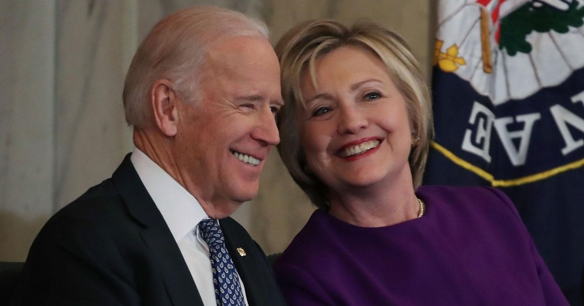 Former Secretary of State Hillary Clinton, right, shares a laugh with then-Vice President Joe Biden during a portrait unveiling ceremony for outgoing Senate Minority Leader Harry Reid on Capitol Hill on Dec. 8, 2016, in Washington, D.C.