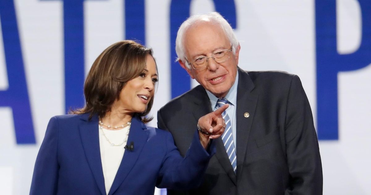 California Democratic Sen. Kamala Harris, left, and Vermont independent Sen. Bernie Sanders stand on stage as they are introduced for a Democratic presidential primary debate hosted by CNN/New York Times at Otterbein University on Oct. 15, 2019, in Westerville, Ohio.