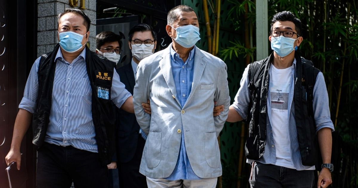Police lead pro-democracy media mogul Jimmy Lai away from his home in Hong Kong on Aug. 10, 2020.