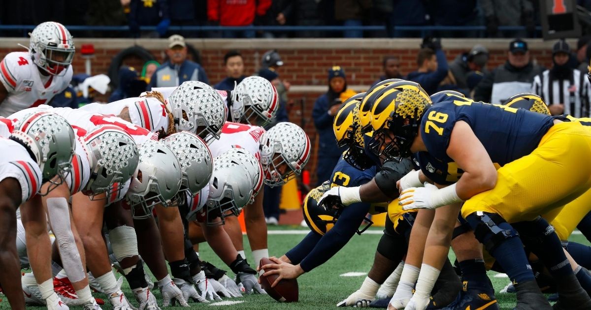 Ohio State and Michigan players play at the line of scrimmage in the first half of an NCAA college football game in Ann Arbor, Michigan, on Nov. 30, 2019.