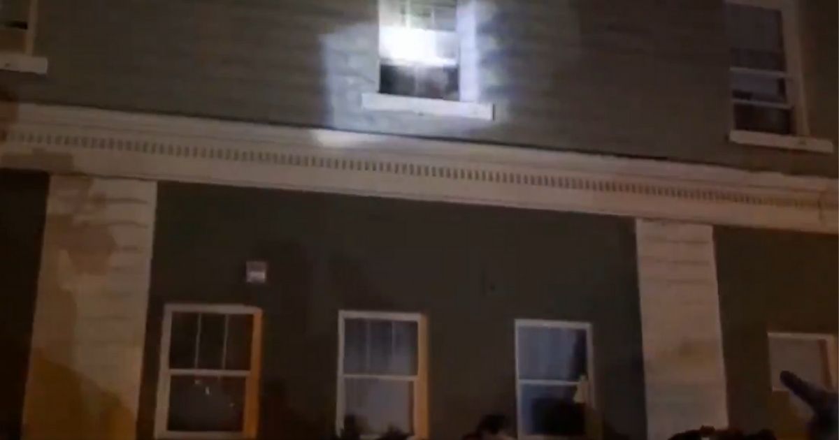 Demonstrators in Portland, Oregon, shine flashlights at residents watching them.