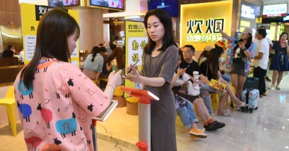 Customers of the Chuiyan Fried Beef restaurant in the Chinese city of Changsha stand on scales.