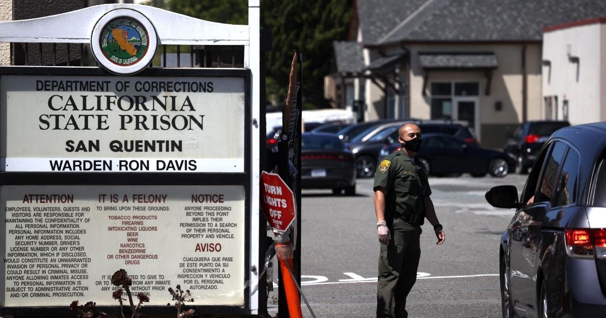 A California Department of Corrections and Rehabilitation stands guard at the front gate of San Quentin State Prison on June 29, 2020