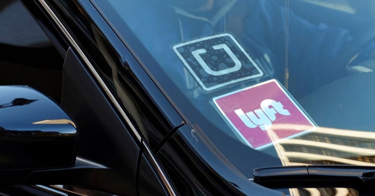 A car displays Lyft and Uber stickers on its front windshield in downtown Los Angeles on Jan. 12, 2016.