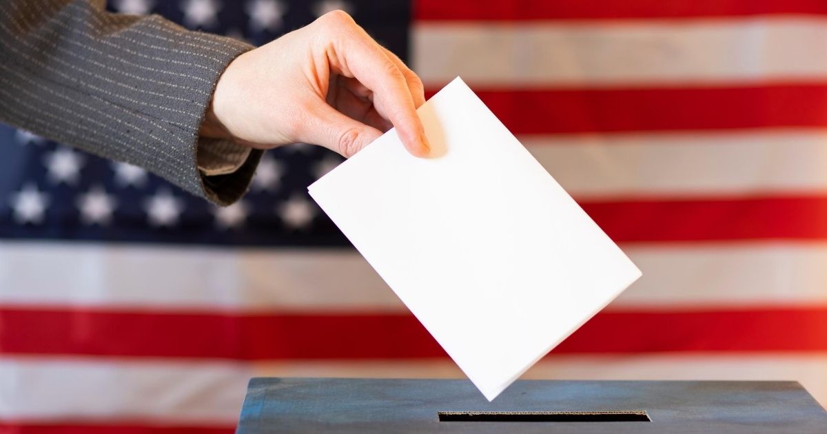 A stock image of a woman placing her ballot in a ballot box is pictured above.