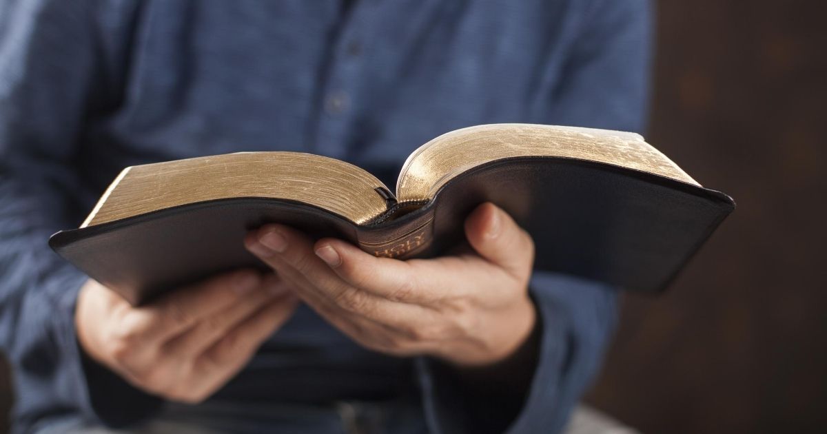 A stock image of a man reading the Bible is pictured above.