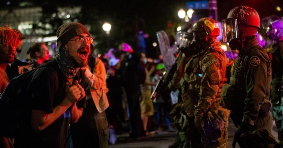 A protester screams at federal officers in front of the Mark O. Hatfield U.S. Courthouse in the early hours of July 30, 2020, in Portland, Oregon.
